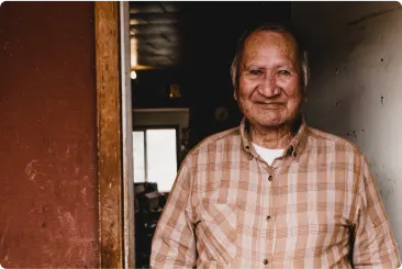 A middle-aged Indigenous man standing in a doorway