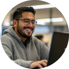 Smiling man sitting in front of an open laptop