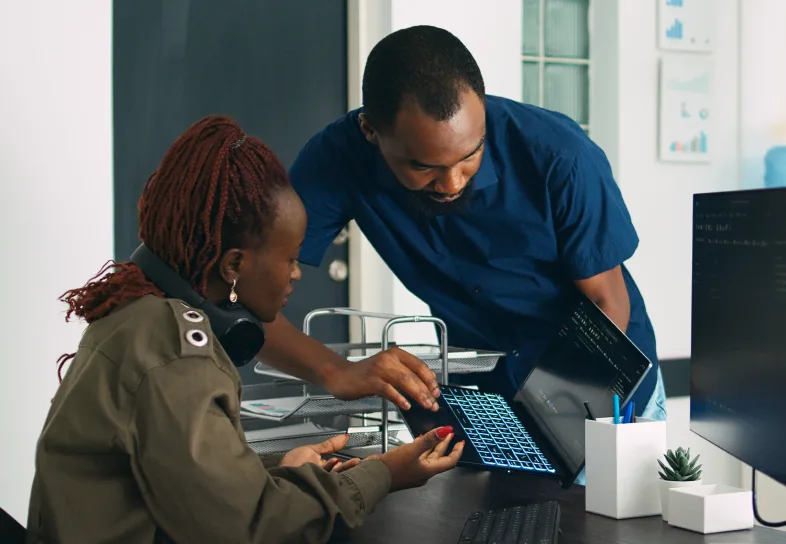 Two people working with one another in an office.