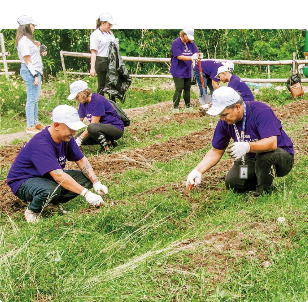 TELUS International team members preparing soil in a community garden in New Lucena.