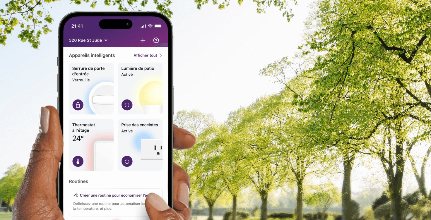 Personne marchant dans un parc avec à la main un appareil sur lequel s’affichent les fonctionnalités de contrôle des thermostats, des prises intelligentes et des horaires de l’application TELUS MC+. 