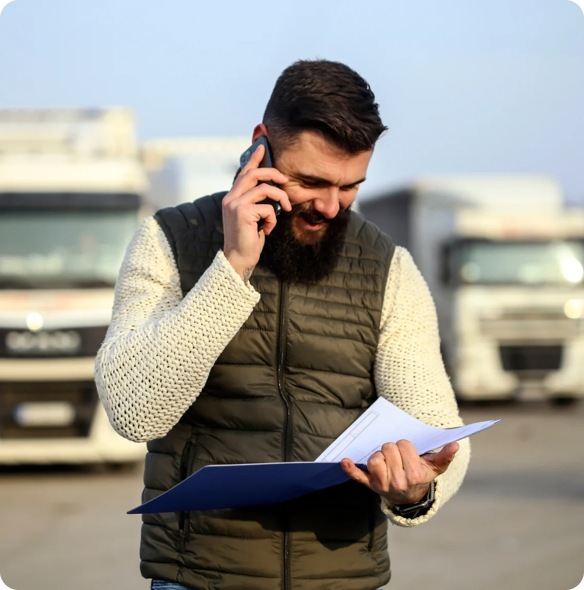 A man in the driver's seat of a truck, working on a laptop, focused on his task.