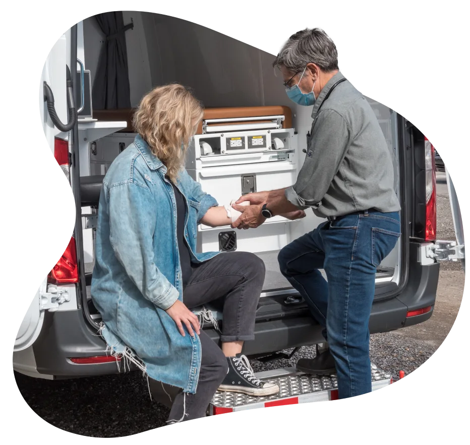 A TELUS Health Mobile Clinic service provider administering care to a woman.