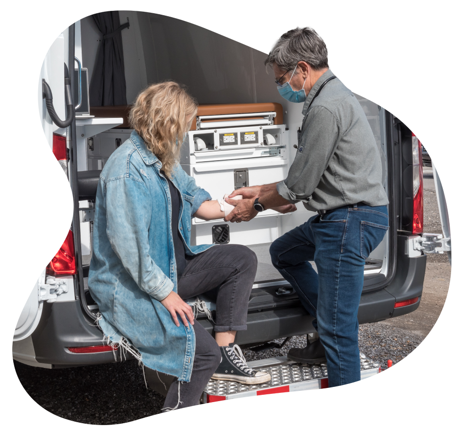 A TELUS Health Mobile Clinic service provider administering care to a woman.
