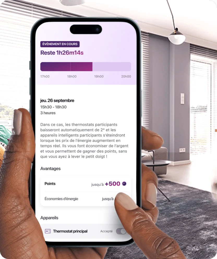 Une main tient un téléphone intelligent qui montre l’application de récompenses d’énergie avec un salon moderne en arrière-plan