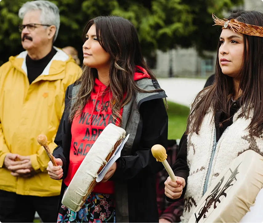 Les participants à la Journée de la campagne Moose Hide dans un cercle de tambours pour exprimer leur engagement à mettre fin à la violence fondée sur le genre.
