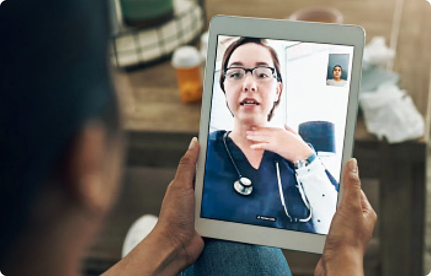 A person having a virtual medical consultation on a tablet screen