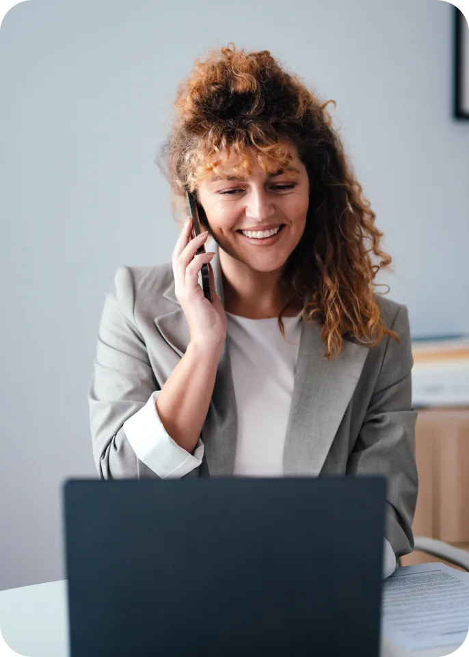 Businesswoman on phone call while working on laptop