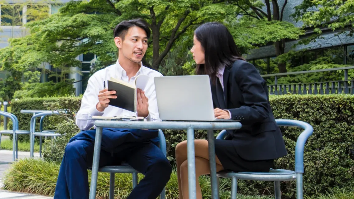 A couple of partners working together while using their mobile device.