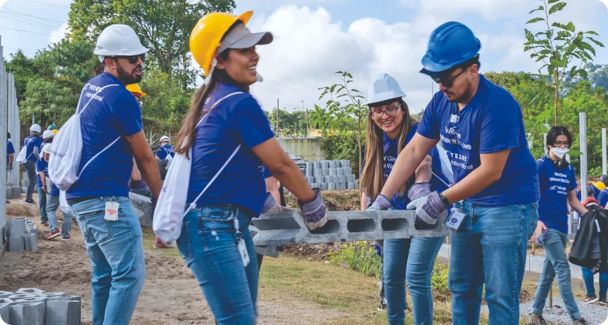 Membres de l’équipe TELUS International transportant des matériaux pour construire une école au Guatemala