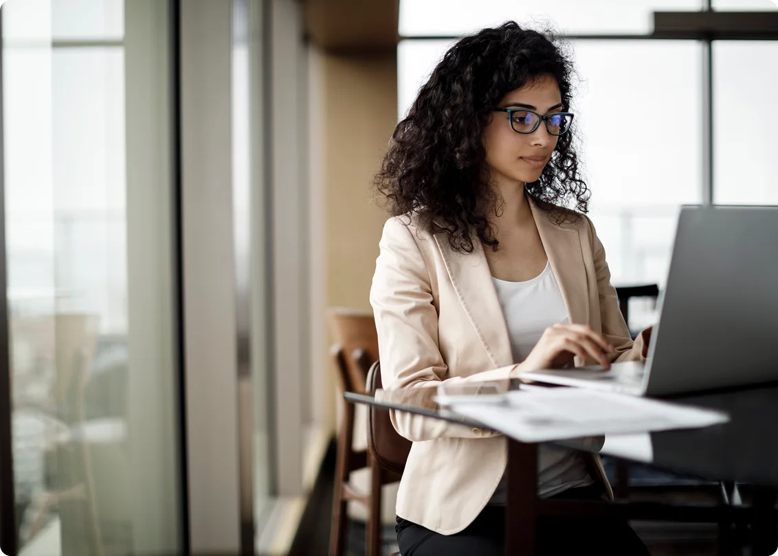 Professional woman working on laptop in modern office.