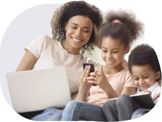 A family sitting together on the couch, laughing and sharing devices connected to TELUS Pure Fibre