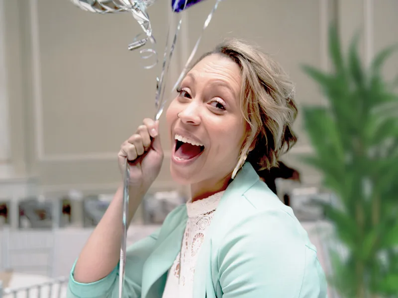 Woman smiling holding balloons