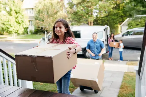 A family moving their belongings into their new home