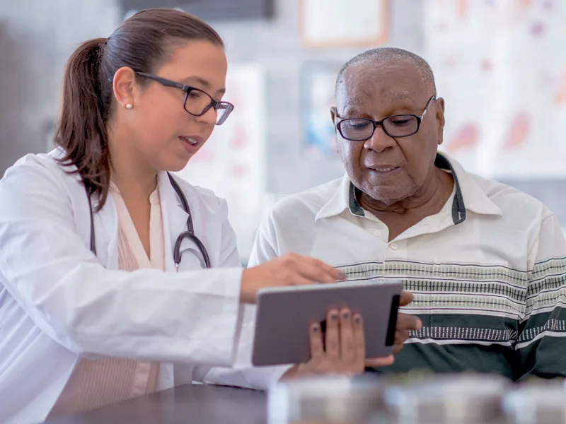 A doctor and patient looking at an iPad