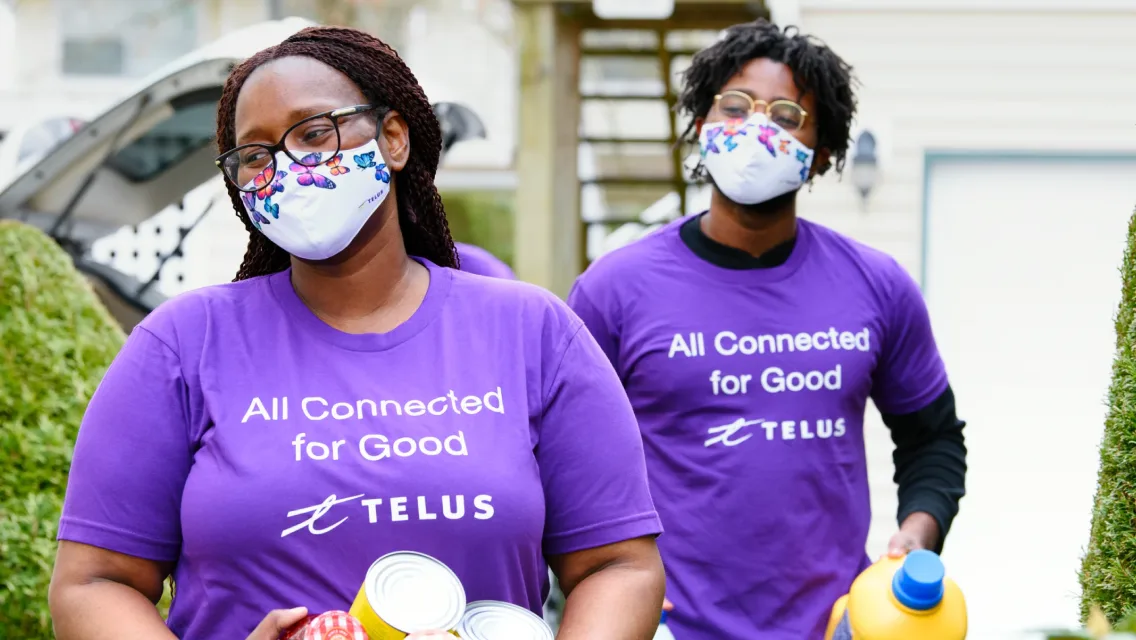 Deux employés TELUS avec des produits d'assainissement, qui s'en vont voir des clients. 