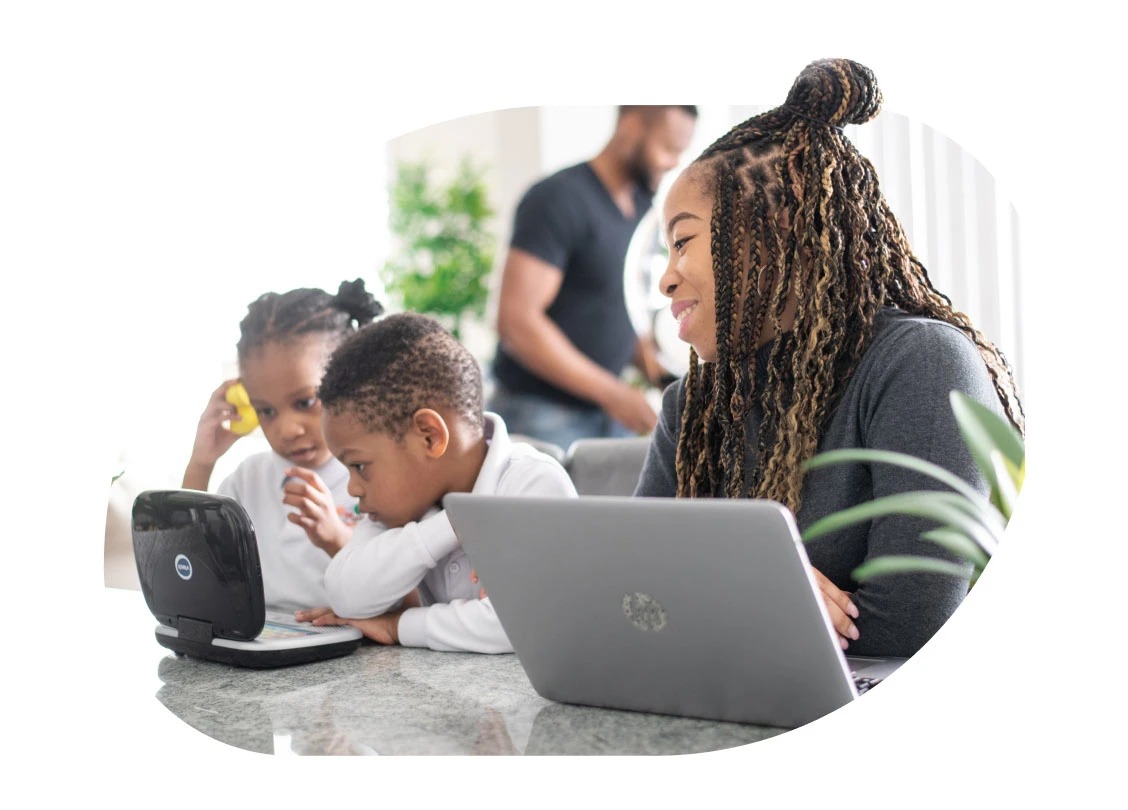 Woman working on her laptop alongside her kids with another laptop