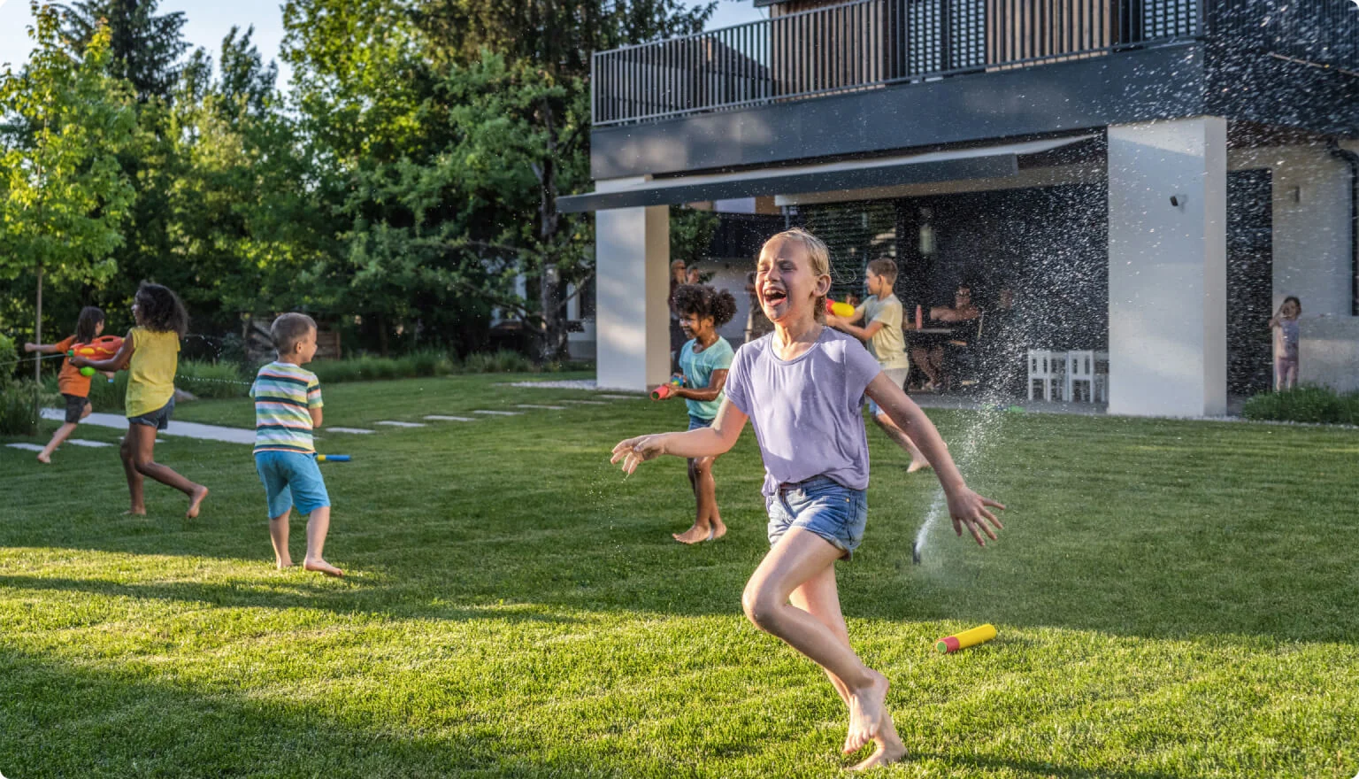 A TELUS Outdoor Camera shows a family playing in the backyard. 