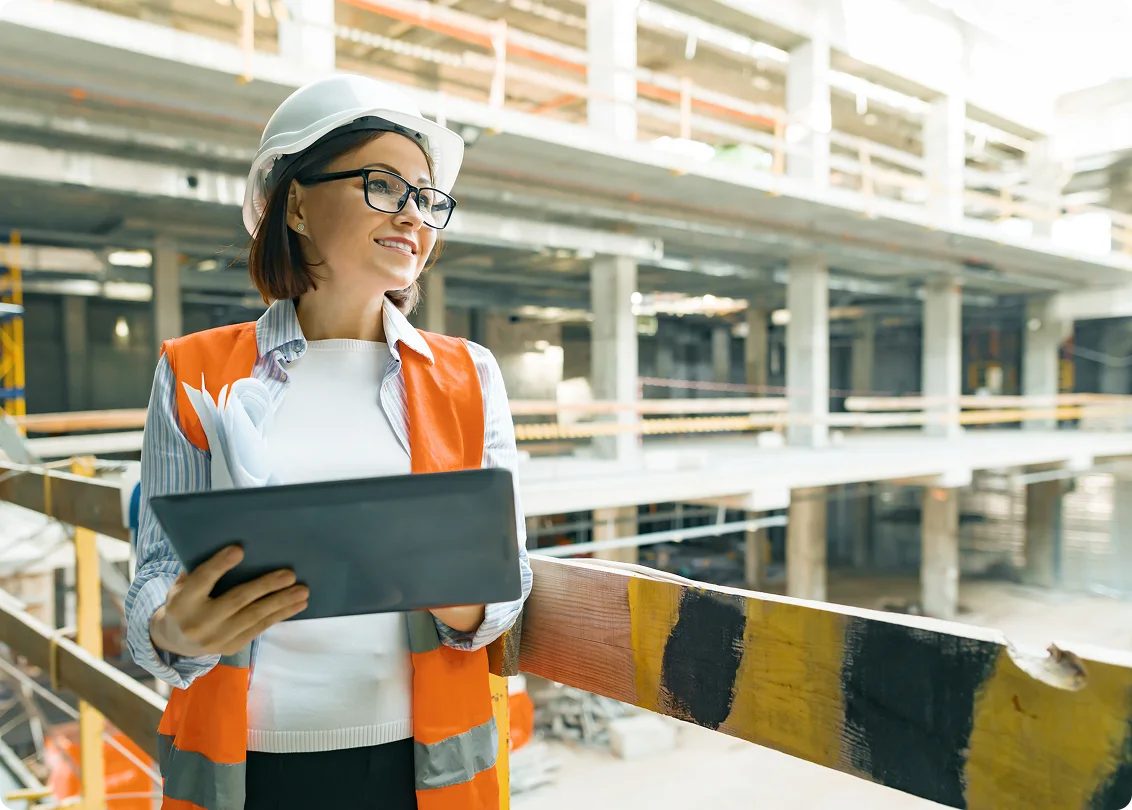 Construction site manager with tablet overseeing facility operations.