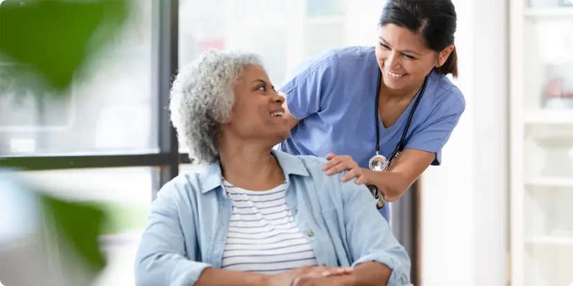 Seated woman smiling at healthcare professional behind her