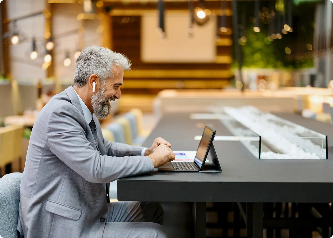 Business professional working on laptop in contemporary cafe.