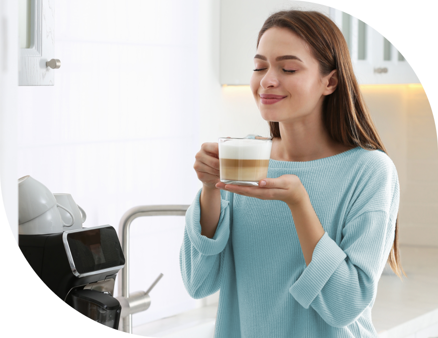 A woman enjoys her morning coffee that was ready when she woke up because her smart plug started the coffee maker.