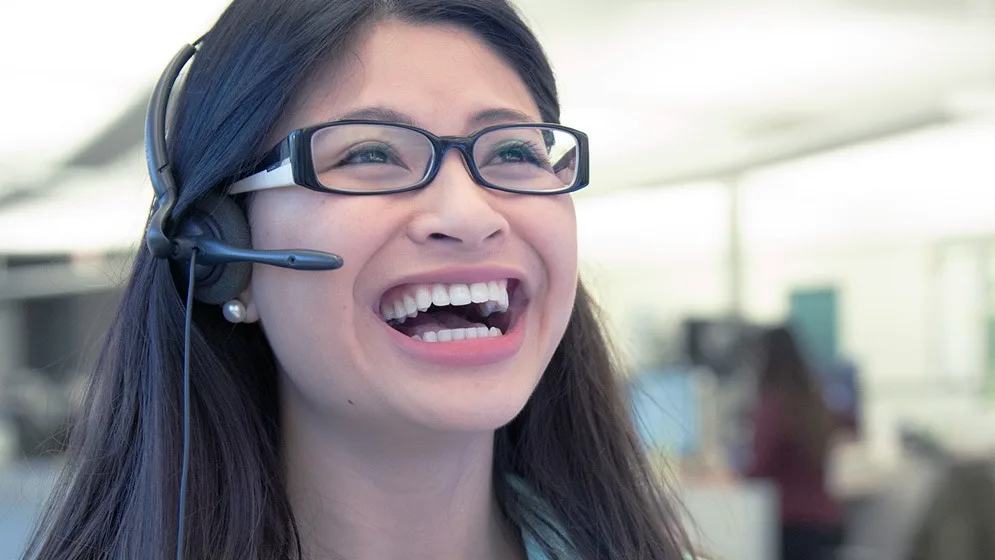 Smiling contact centre representative talking on a headset