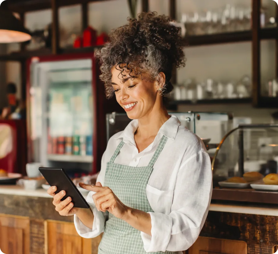 A woman at a restaurant on her tablet