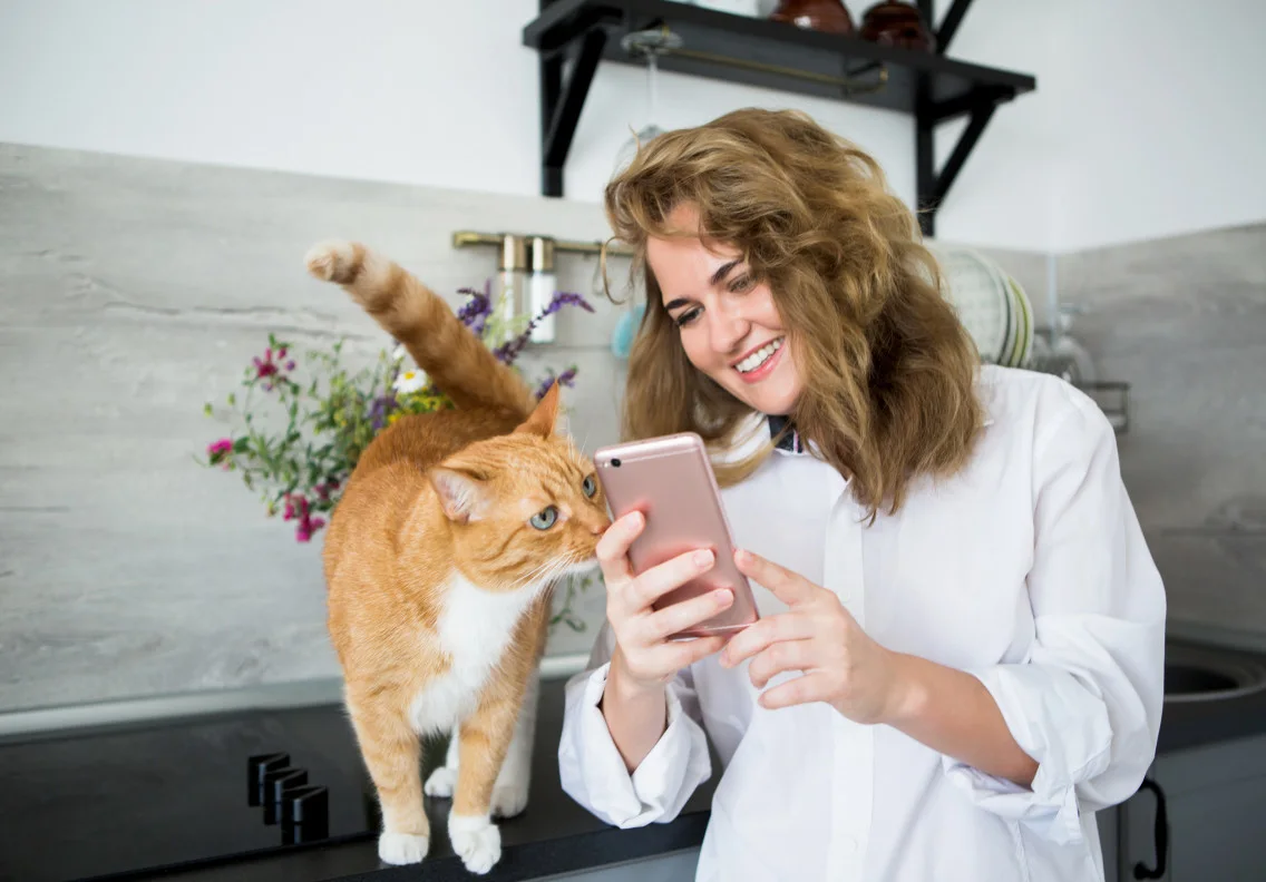 Woman looking at her phone with her cat