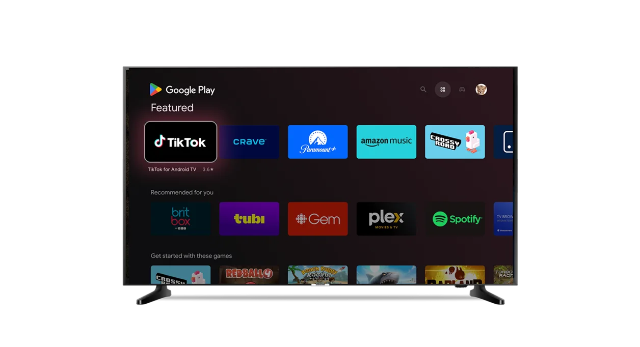 A TV screen showing the Google Play interface with featured apps like TikTok, Crave, Paramount+, Amazon Music and Spotify.