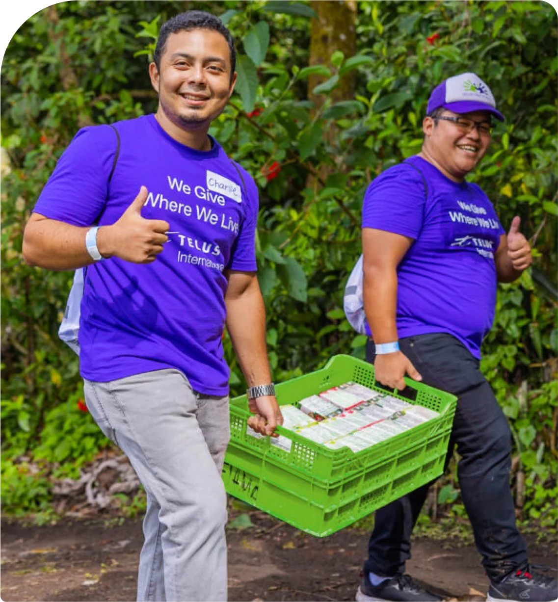 Two TELUS team members carrying a crate of groceries.