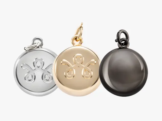 Three SmartWear Security safety charms in silver, gold and gunmetal grey.
