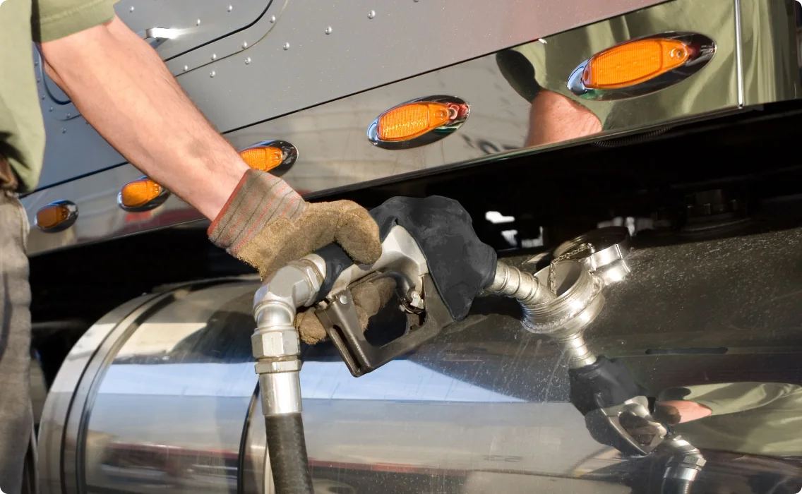 A man refilling fuel in a truck's fuel tank