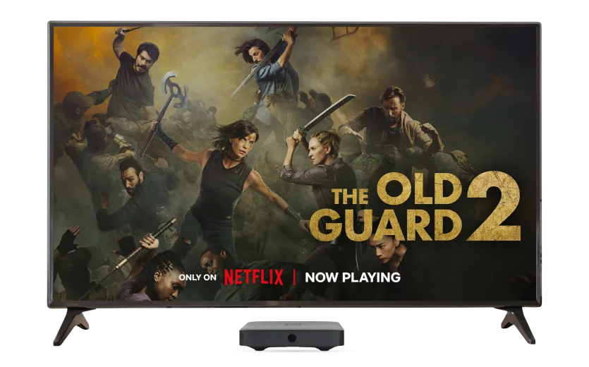 An image showing the Netflix show: Old Guard 2 on a 4k TV screen with a TV Box on the foreground.