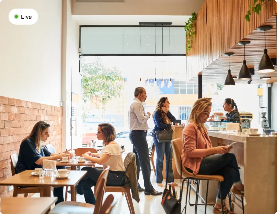 Busy modern restaurant interior with customers dining at tables and ordering at counter