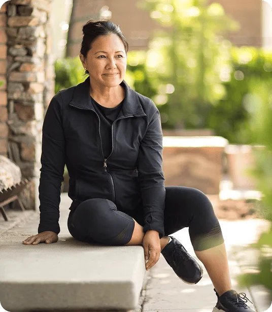 Femme en tenue de sport se reposant à l'extérieur après une séance d’exercice.