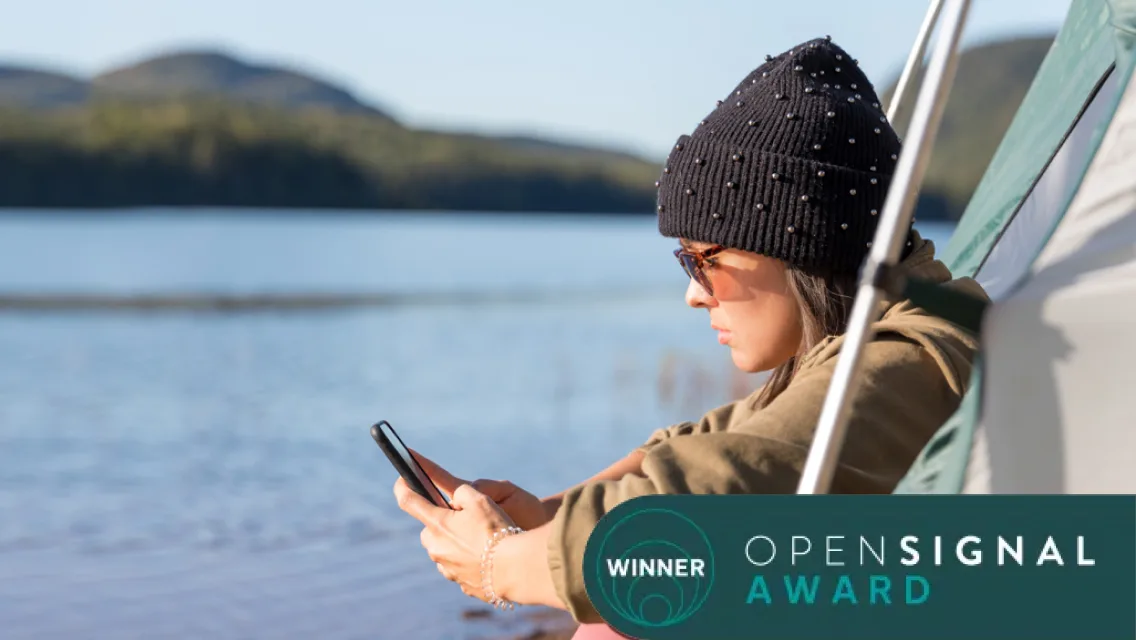 Girl on a boat on a lake using her phone, with a "Winner-Open Signal" logo over the top