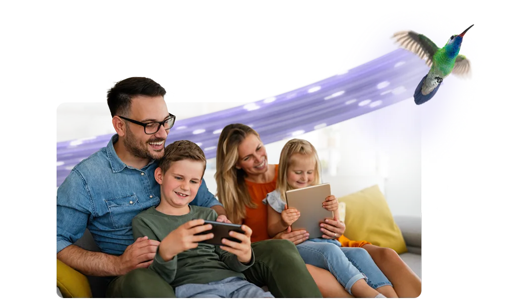 A family of four enjoying time on their devices with a TELUS critter flying in the background