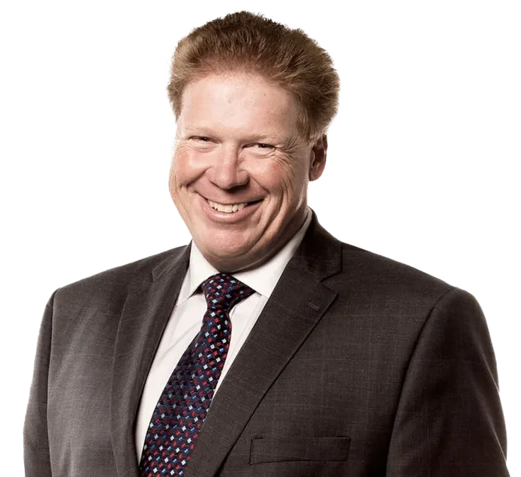 Headshot portrait of Doug French, CFO of TELUS, with a broad smile, wearing a dark suit, white shirt, and patterned tie against a white background.