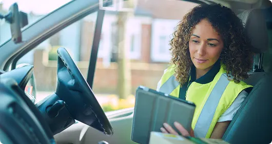 Field service worker reviewing tablet for fleet management tasks.