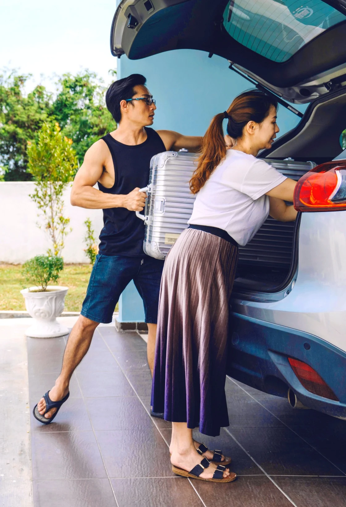 A couple is packing their car for a road trip. 