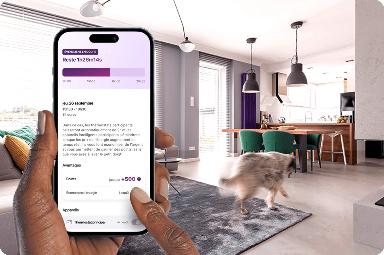Une main tient un téléphone intelligent qui montre l’application de récompenses d’énergie avec un salon moderne en arrière-plan