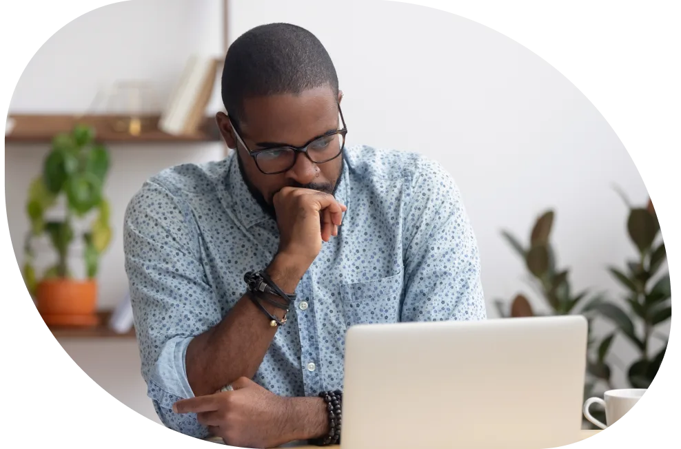 A person seated in front of their laptop, reading tips on how to spot a tax scam.