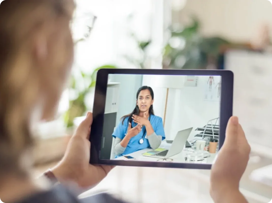 A woman speaking with a healthcare professional on her tablet.