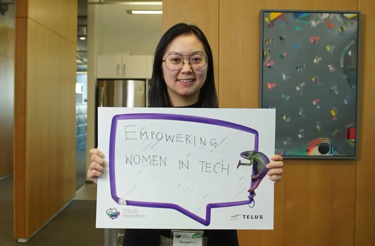 A student holding a sign that reads “Empowering women in tech”