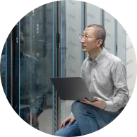 Un homme assis avec son ordinateur portatif.