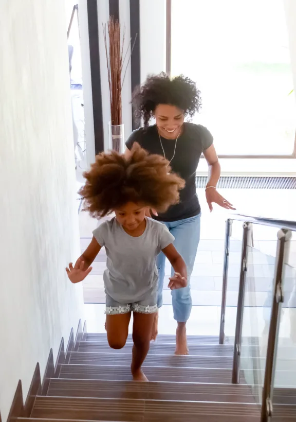 A TELUS Indoor Camera captures a family running up the stairs in the house. 