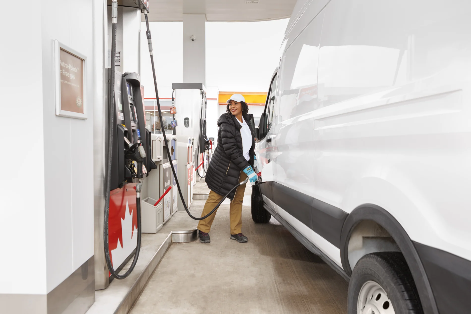 A female driver is refueling her vehicle with gasoline.