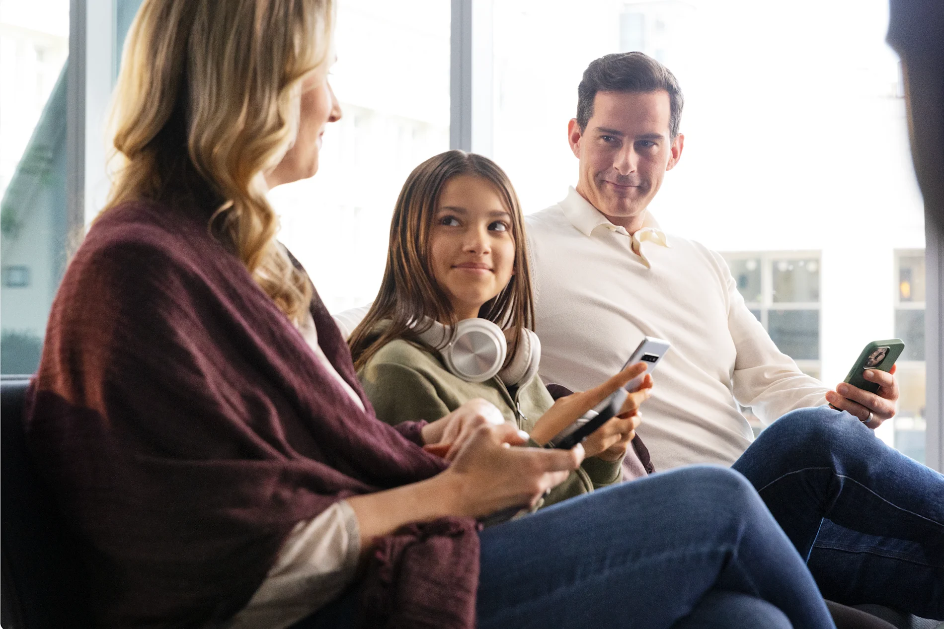 An image of a family hanging out while each of them are holding a mobile phone.