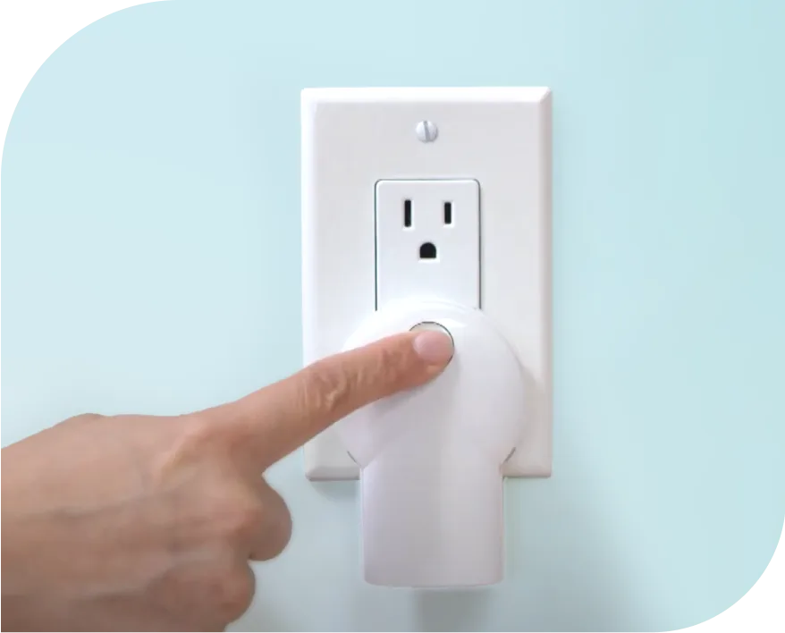 A Smart Plug in action with someone pressing the set button.